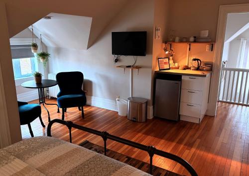 a room with a bed and a table and a kitchen at Gite du Quartier des Arts in Quebec City