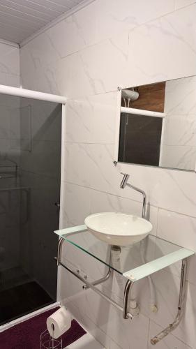 a white bathroom with a sink and a mirror at Casa vista infinita in Mangaratiba