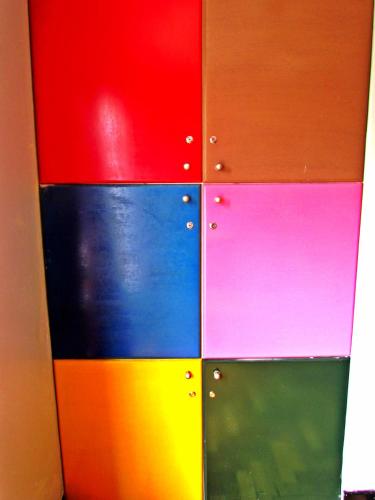 a colorful wall with different colored doors at La Casa Azul Hostel in Valparaíso