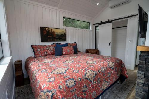 a bedroom with a bed with a red comforter at River Falls Retreat in Oakhurst