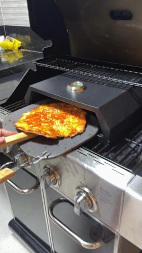 a pizza sitting on top of a stove at Recanto da Praia in Anchieta