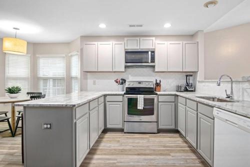 a kitchen with white cabinets and a stove top oven at The Suite Carolinas in Charleston
