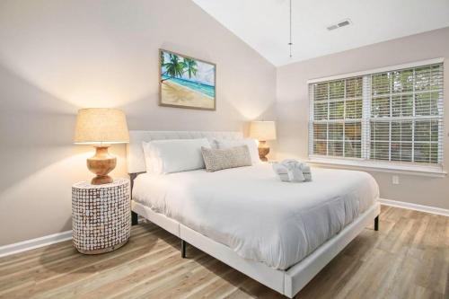 a bedroom with a white bed and two lamps at Suite Carolina in Charleston