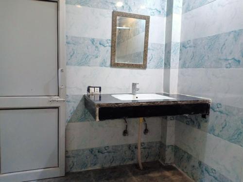 a bathroom with a sink and a mirror at Hotel Alpine in Chandīgarh