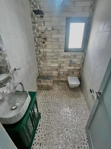 a bathroom with a sink and a toilet and a window at L Andalousie in Tabarka