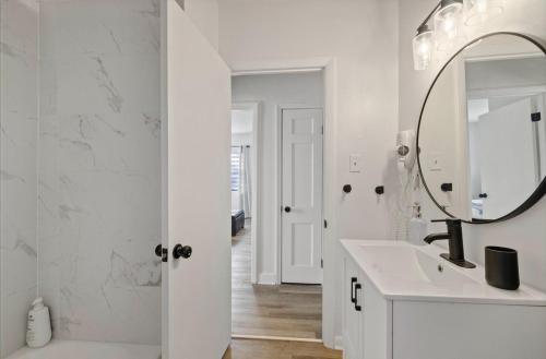 a white bathroom with a sink and a mirror at La Casita St Pete in St. Petersburg