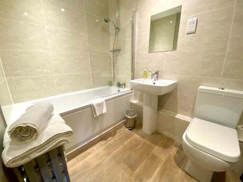 a bathroom with a sink and a toilet and a tub at Kings Head - Riverside, Ravenstonedale in Ravenstonedale