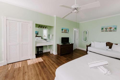 a bedroom with a bed and a couch and a sink at King Suite at Curry Mansion with Heated Pool! in Key West