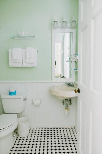 a bathroom with a toilet and a sink and a mirror at King Suite at Curry Mansion with Heated Pool! in Key West
