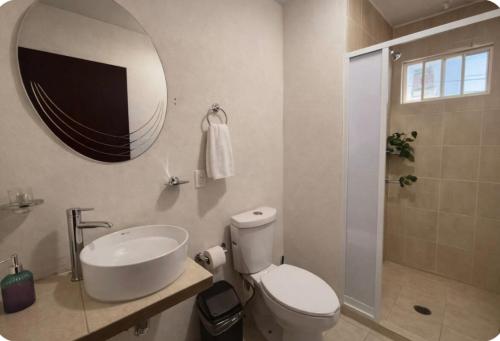 a bathroom with a toilet and a sink and a mirror at Hotel El Balcón in Zacatlán