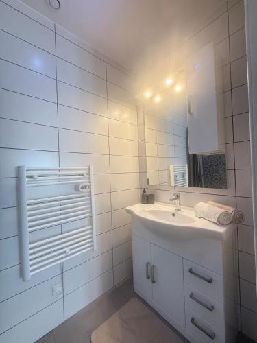 a white bathroom with a sink and a mirror at La Pause Alpine - Centre Ville - Proche Gare in Saint-Jean-de-Maurienne