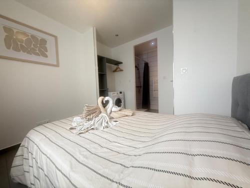 a bedroom with a white bed with towels on it at La Pause Alpine - Centre Ville - Proche Gare in Saint-Jean-de-Maurienne