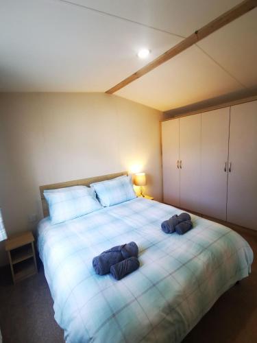 a bedroom with a large bed with two pillows on it at Willows Lodge with self contained garden in Carlisle