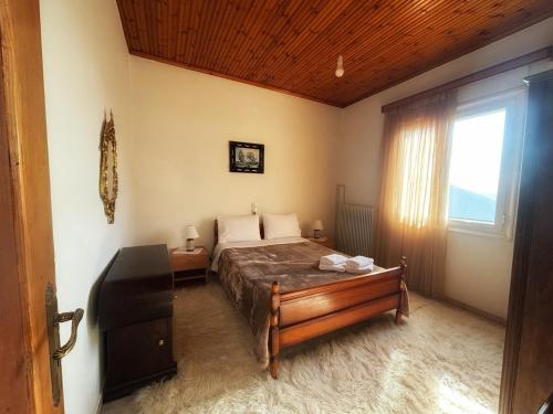 a bedroom with a bed in a room with a window at Georgaras Accommodation in Platanoússa
