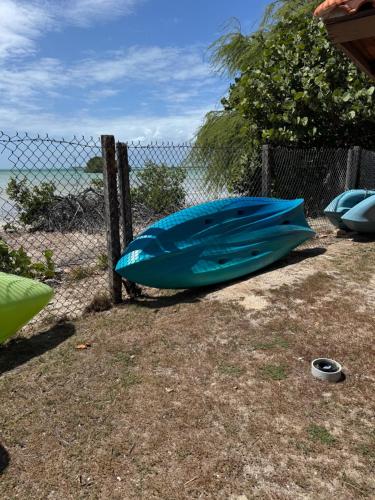 a blue boat sitting on the ground next to a fence at Condo Ocean View from Balcony Swimming Pool Playa Sucia in Cabo Rojo