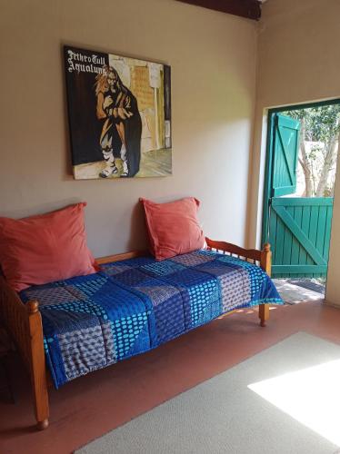 a bedroom with a bed and a picture on the wall at Karoo Saloon in Barrydale