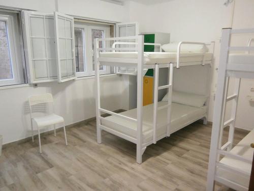 a room with two bunk beds and a chair at A Barca de Pedra in Padrón