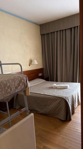 a hotel room with a bed and a chair at UNITY BANK HOTEL Termale Padova RC12 in Abano Terme