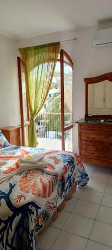 a bedroom with a bed and a window and a dresser at Perla del Mare in Sperlonga