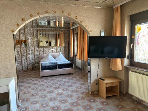a room with a bed and a flat screen tv at Central Hotel in Schwetzingen