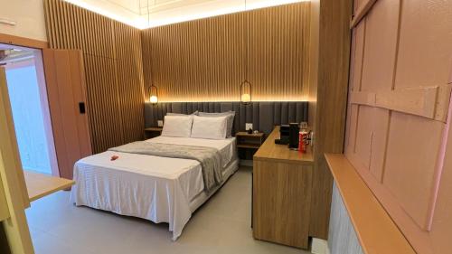 a bedroom with a bed and a wooden wall at Encantos Pousada Boutique in Pirenópolis