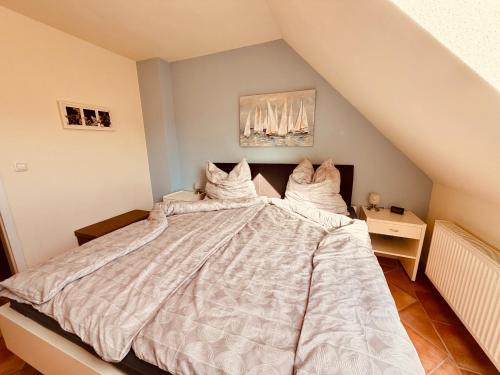 a bedroom with a large bed with white comforter at Maisonette am See in Seedorf