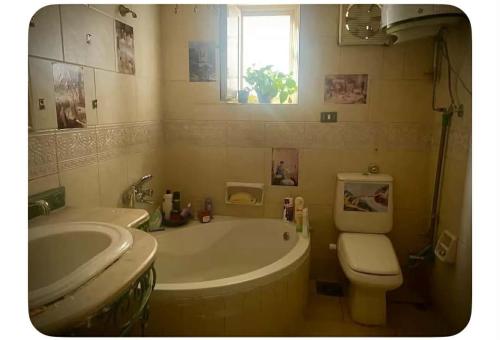 a bathroom with a tub and a toilet and a sink at Baraka in Cairo