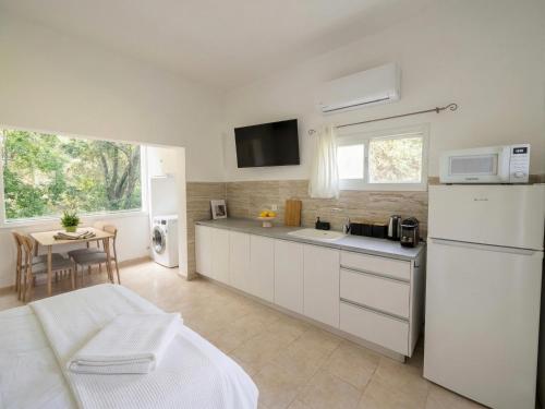 a kitchen with white cabinets and a white refrigerator at White Emerald in Haifa