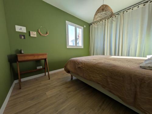 a bedroom with a bed and a table and a window at Maison Terracotta in Saint-Priest-en-Jarez