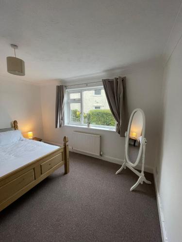 a bedroom with a bed and a mirror and a window at Penrhyn View in Bangor