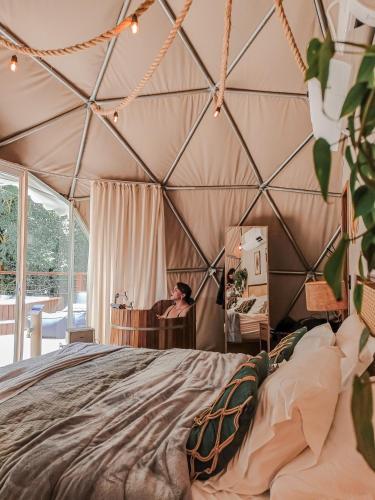 a woman in a geodesic dome bedroom at Goat Lodge DOMO BALI in Ibiúna