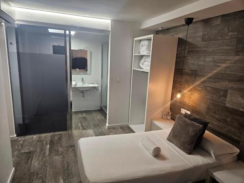 a small bathroom with a bed and a shower at Alojamientos Santa Pola in Santa Pola