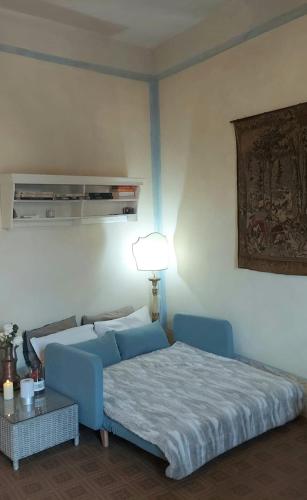 a bedroom with a blue bed and a lamp at Millenovecento in Cremona