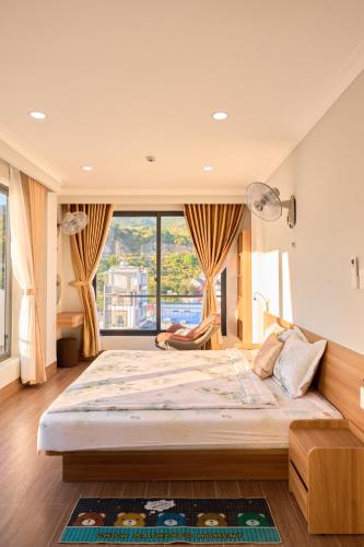 a large bed in a room with a large window at ArionHotel in Ninh Hải