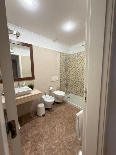 a bathroom with two toilets and a sink and a mirror at suites Lisboa areeiro in Lisbon