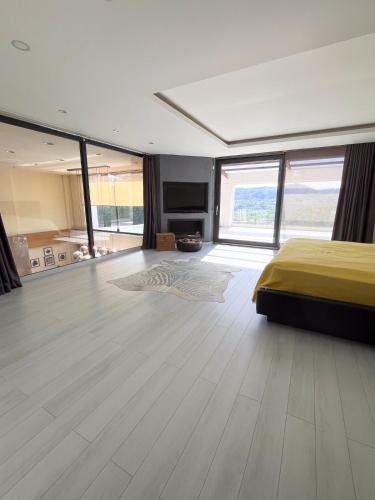 a bedroom with a bed and a large room with windows at Villa Meg with Private Pool, Sauna Jacuzzi in Kadıköy