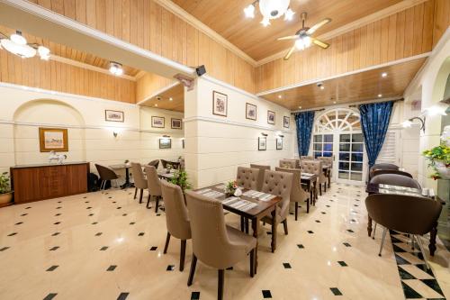 a restaurant with wooden ceilings and tables and chairs at Luxe Avenue Hotel in Dubai
