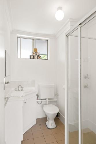 a white bathroom with a toilet and a shower at Georgies Simple Base in Mosman Park in Mosman Park