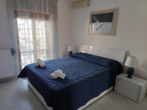 a bedroom with a blue bed with two white towels on it at Sole e relax da Michelle in Anzio