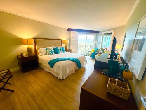 a bedroom with a bed and a television in it at Pristine Hotel Room at Popular Resort in Lihue