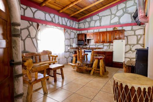 a kitchen with a table and chairs and a refrigerator at Cabañas las Gemelas in Areponapuchi