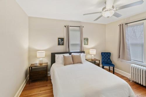 a bedroom with a white bed and a blue chair at USS Alexandria in Highwood