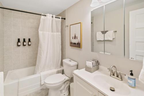 a white bathroom with a toilet and a sink at USS Alexandria in Highwood