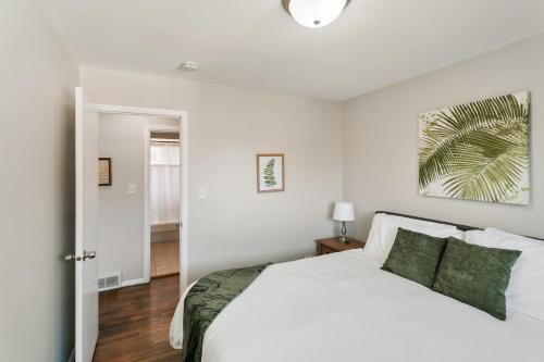 a bedroom with a white bed with green pillows at USS Anderson in Waukegan
