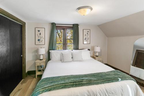 a bedroom with a large white bed and two lamps at USS Maddox in Libertyville