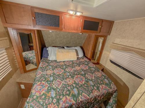 a small bedroom with a bed in an rv at Camper Adventure in Livingston