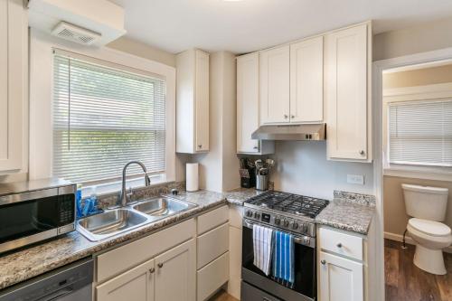 a kitchen with a sink and a stove top oven at Cozy 2 bed Apt 2 train stops to the Naval Base in Highwood