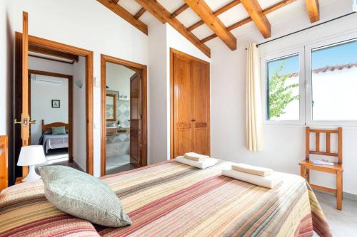 a large bed in a bedroom with a large window at Villa Maru III by Villa Plus in Cala en Porter