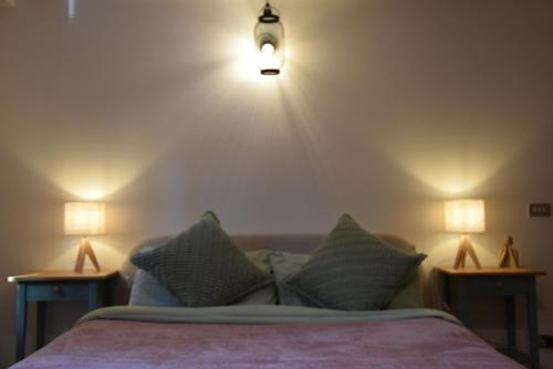 a bedroom with a bed with two lights on the wall at Ponte House in Piaia