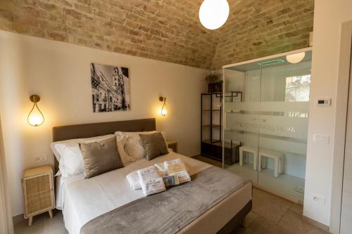 a bedroom with a bed and a brick wall at L'Incanto delle Mura - Boutique B&B ad Altamura in Altamura